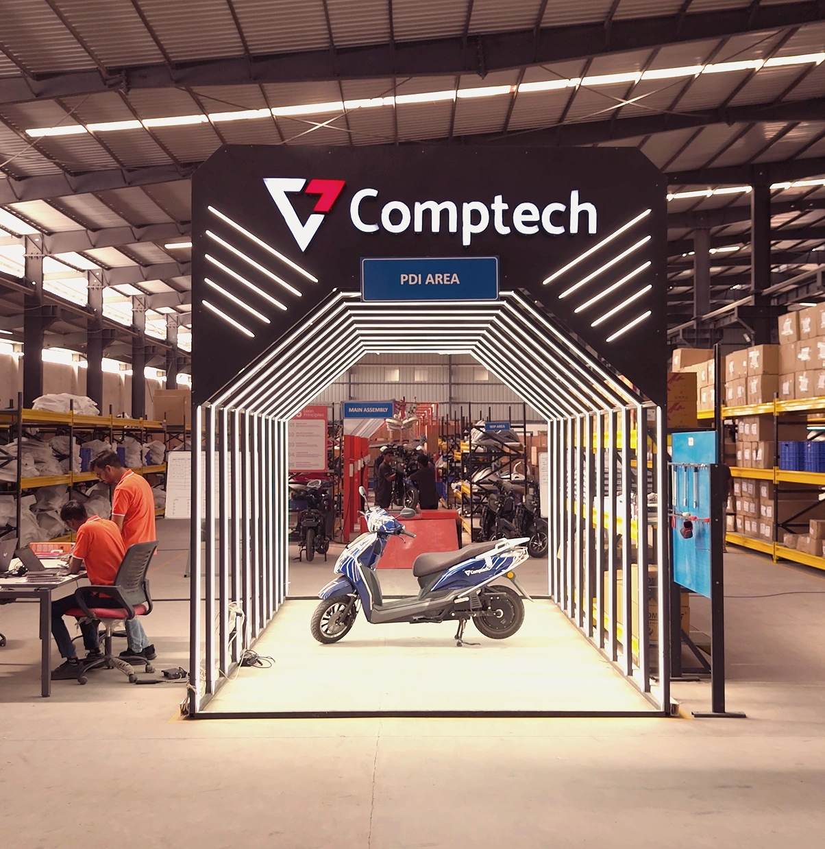 Pre-delivery inspection bay at the Comptech Motocorp plant, a scooter under the branded PDI arch