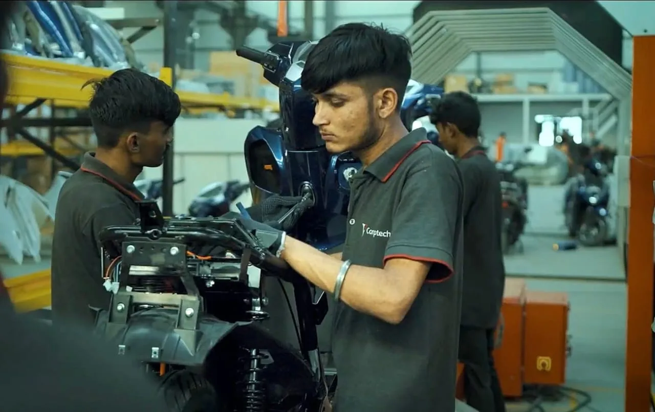 Technicians assembling a Comptech electric scooter
