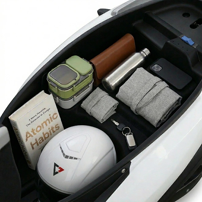 The open boot of a Comptech VX1 holding a helmet, a book, a water bottle and a lunch box