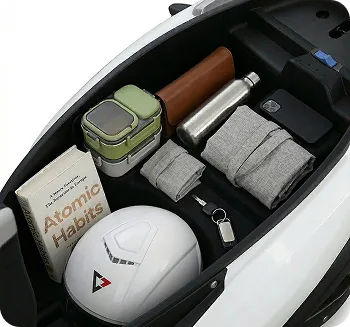 The open boot of a Comptech VX1 holding a helmet, a book, a water bottle and a lunch box